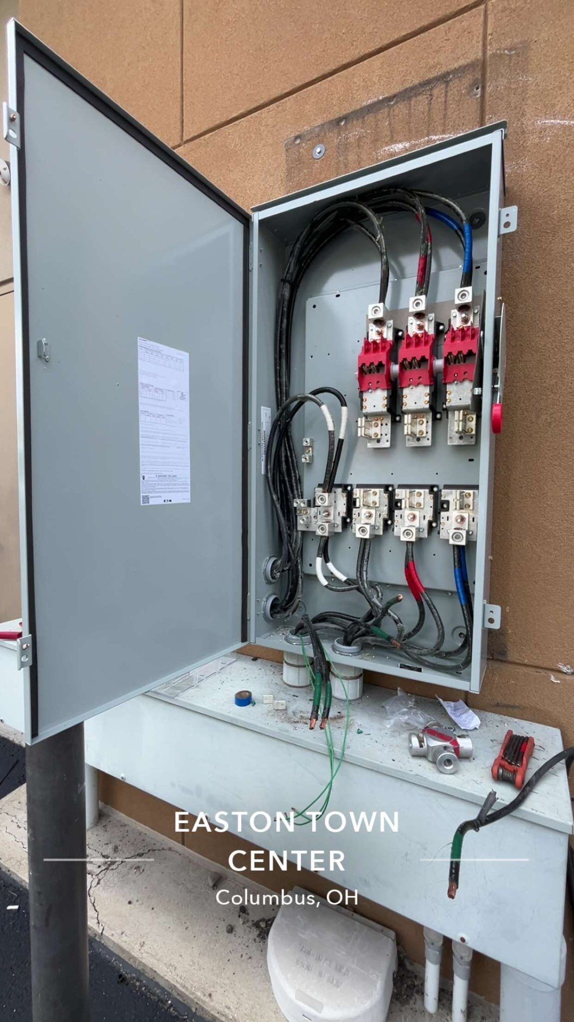 An open outdoor electrical panel showing internal wiring, red disconnect switches, and fuses at Easton Town Center, Ohio.