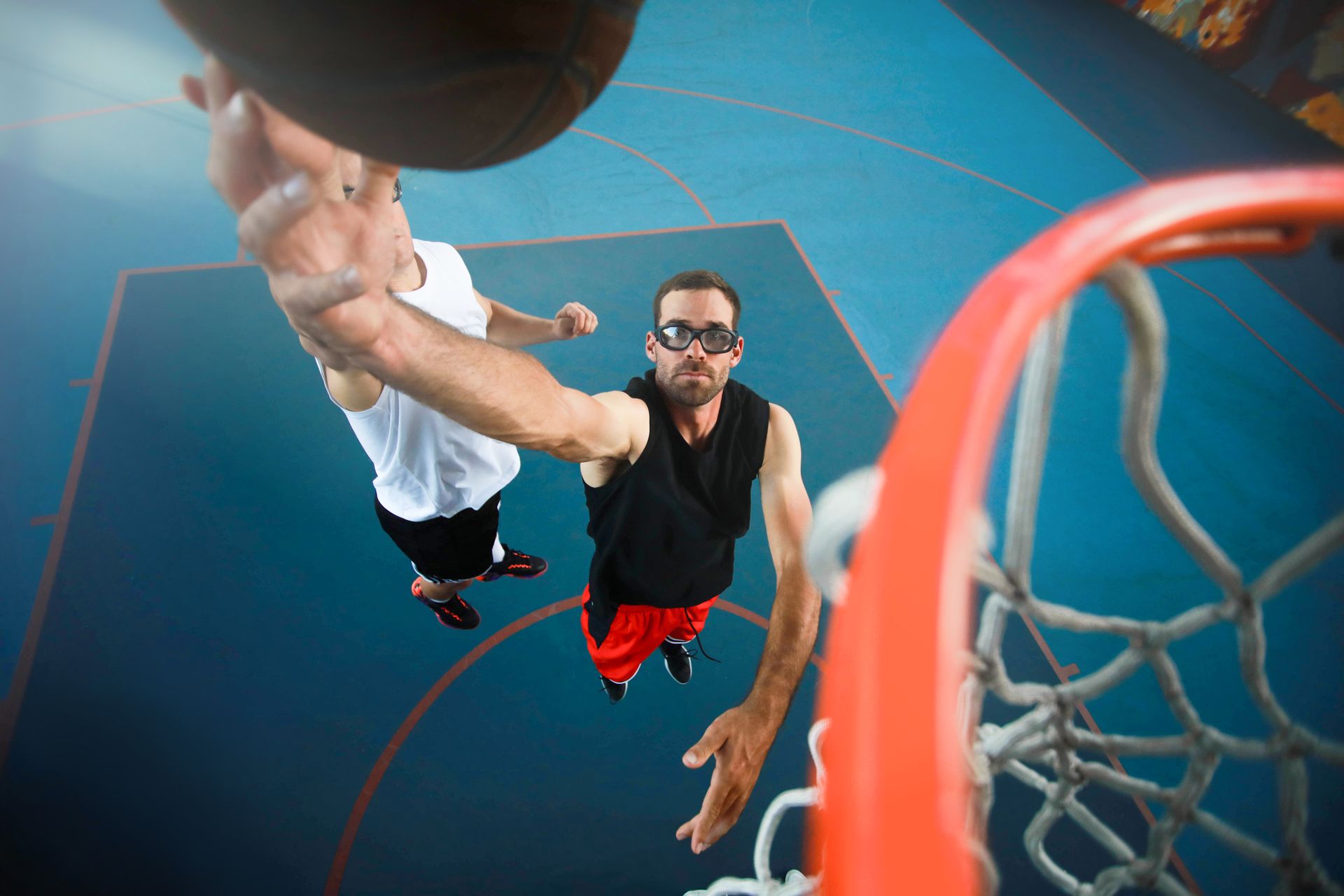 Jeune homme faisant du basket-ball portant des lunettes de sport