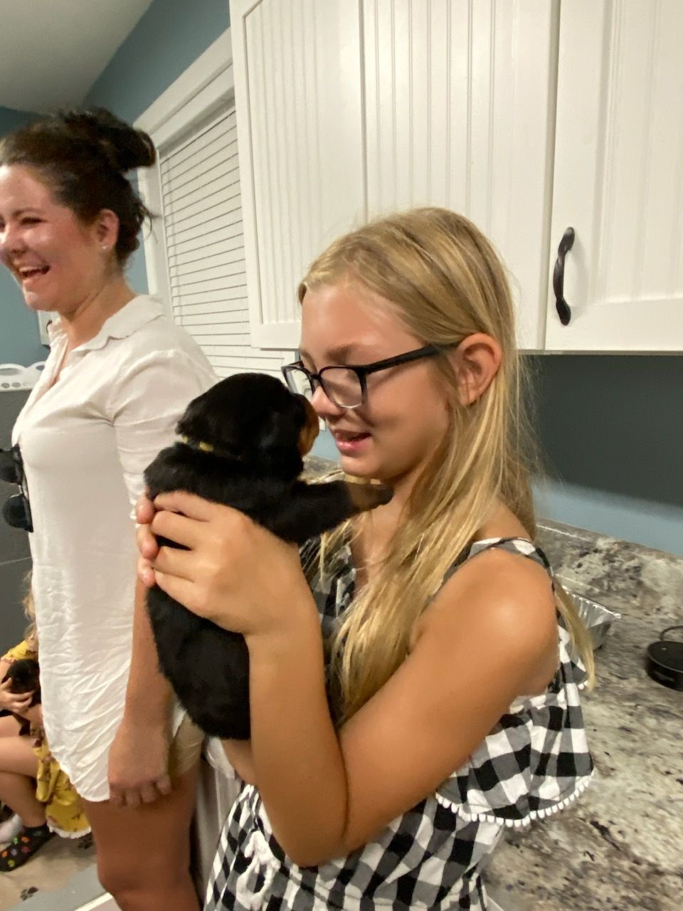Teenage girl hugging a Rottweiler puppy