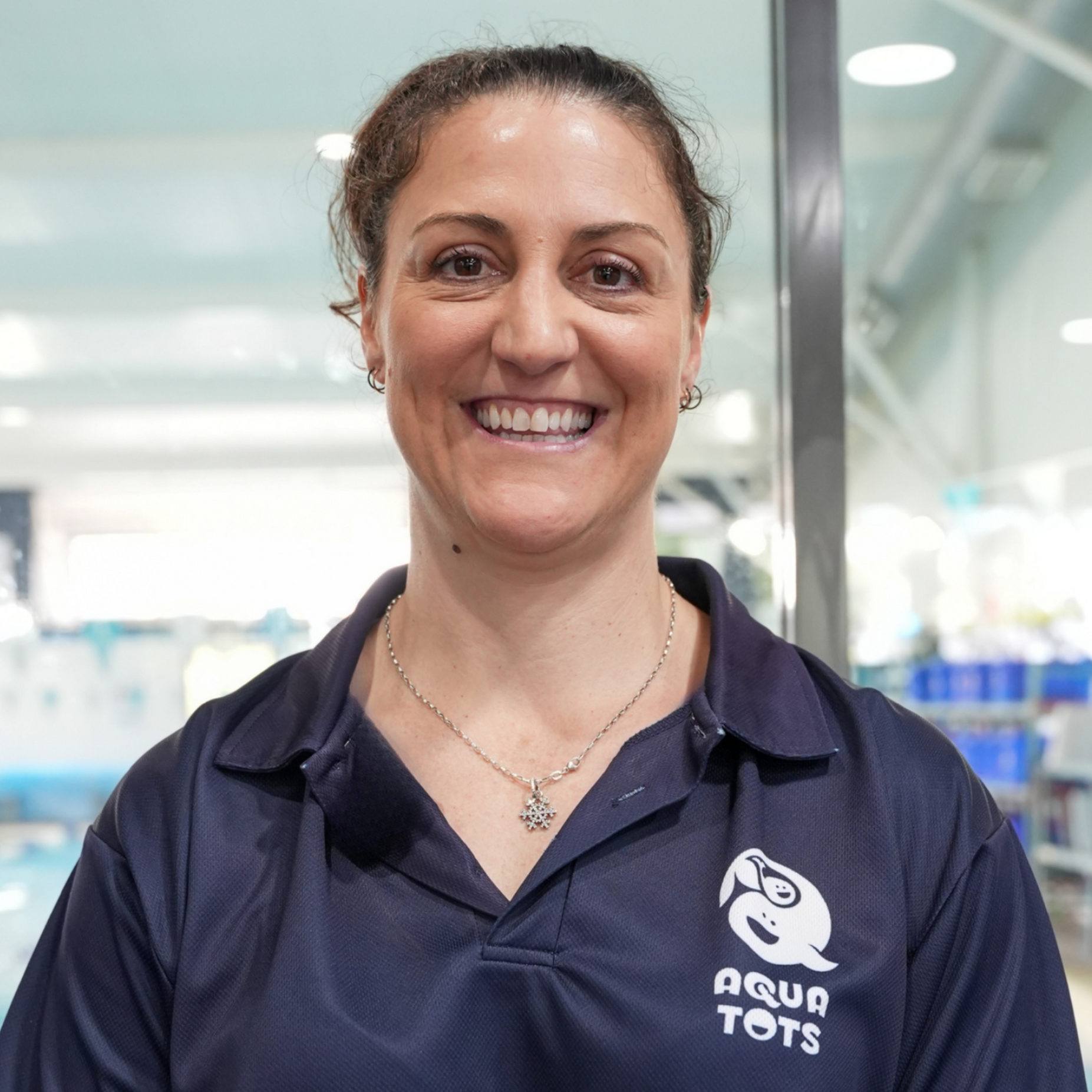 Alena Sarri smiling, wearing a green polo shirt with