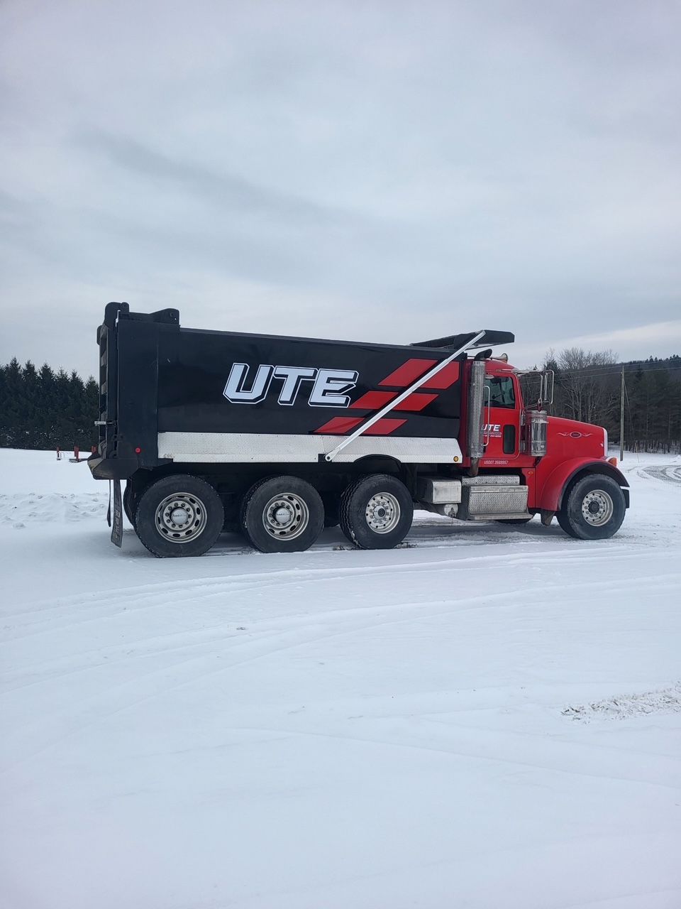 A tow truck is carrying a bulldozer on a flatbed trailer.