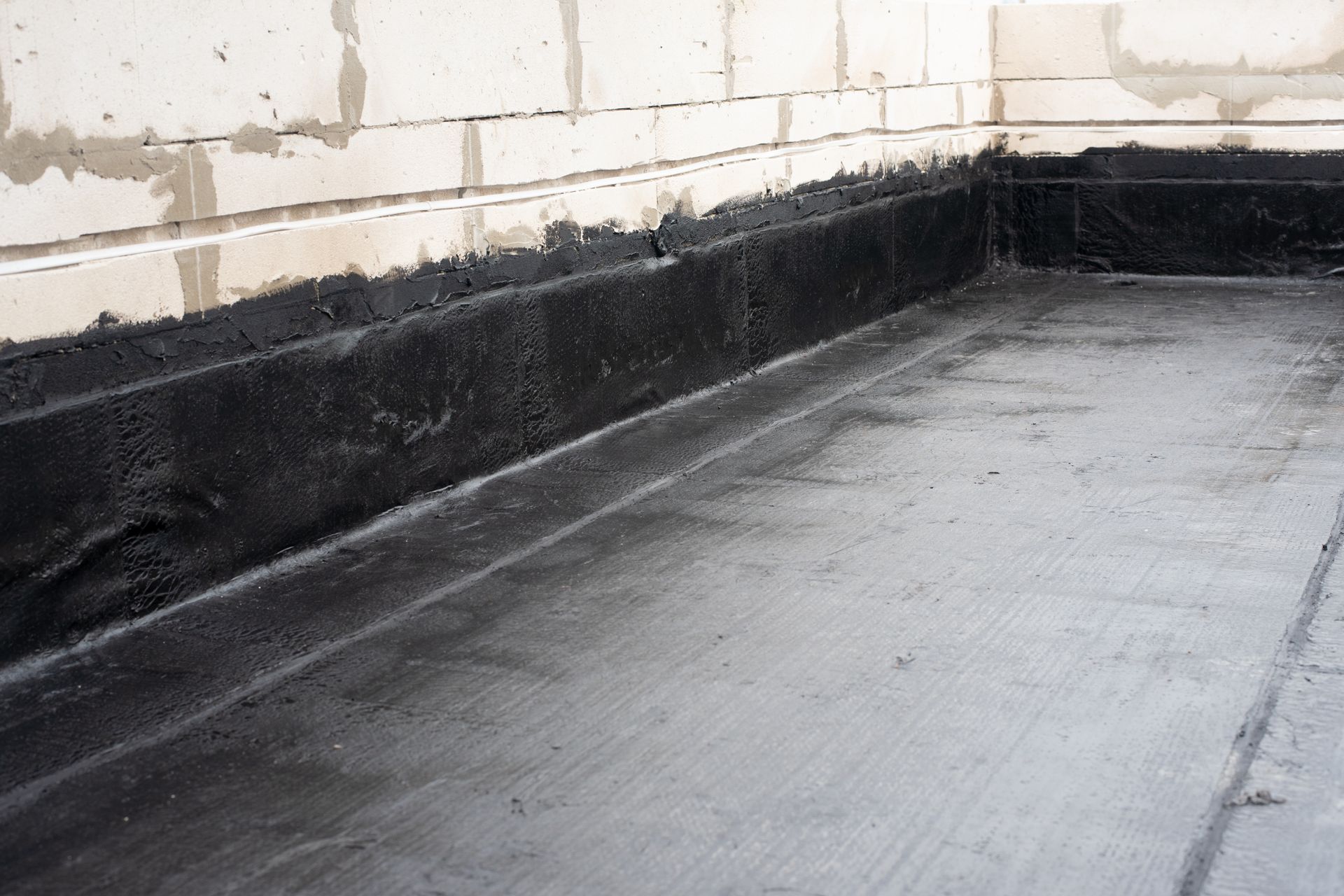 Bl roofing membrane installed along a wall.