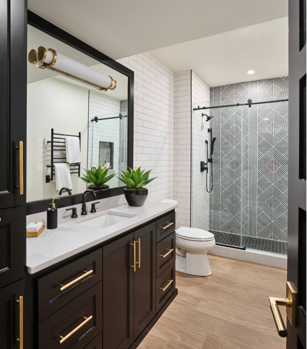 A bathroom with a sink , toilet , shower and mirror