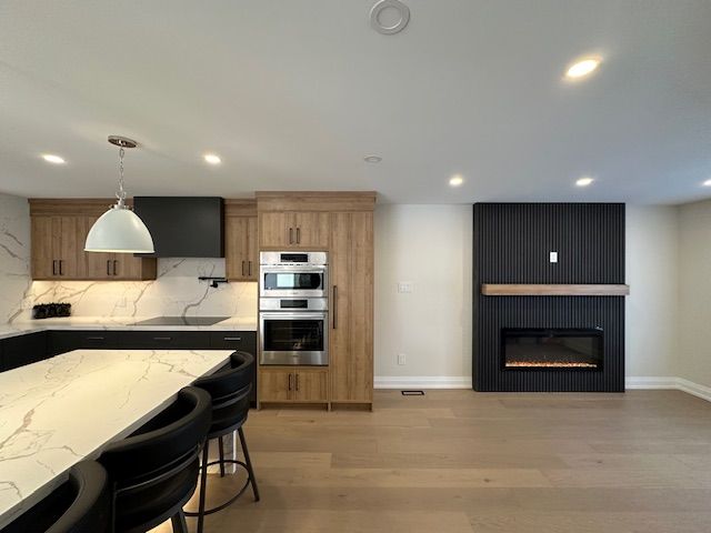 A kitchen with a table and chairs and a fireplace.