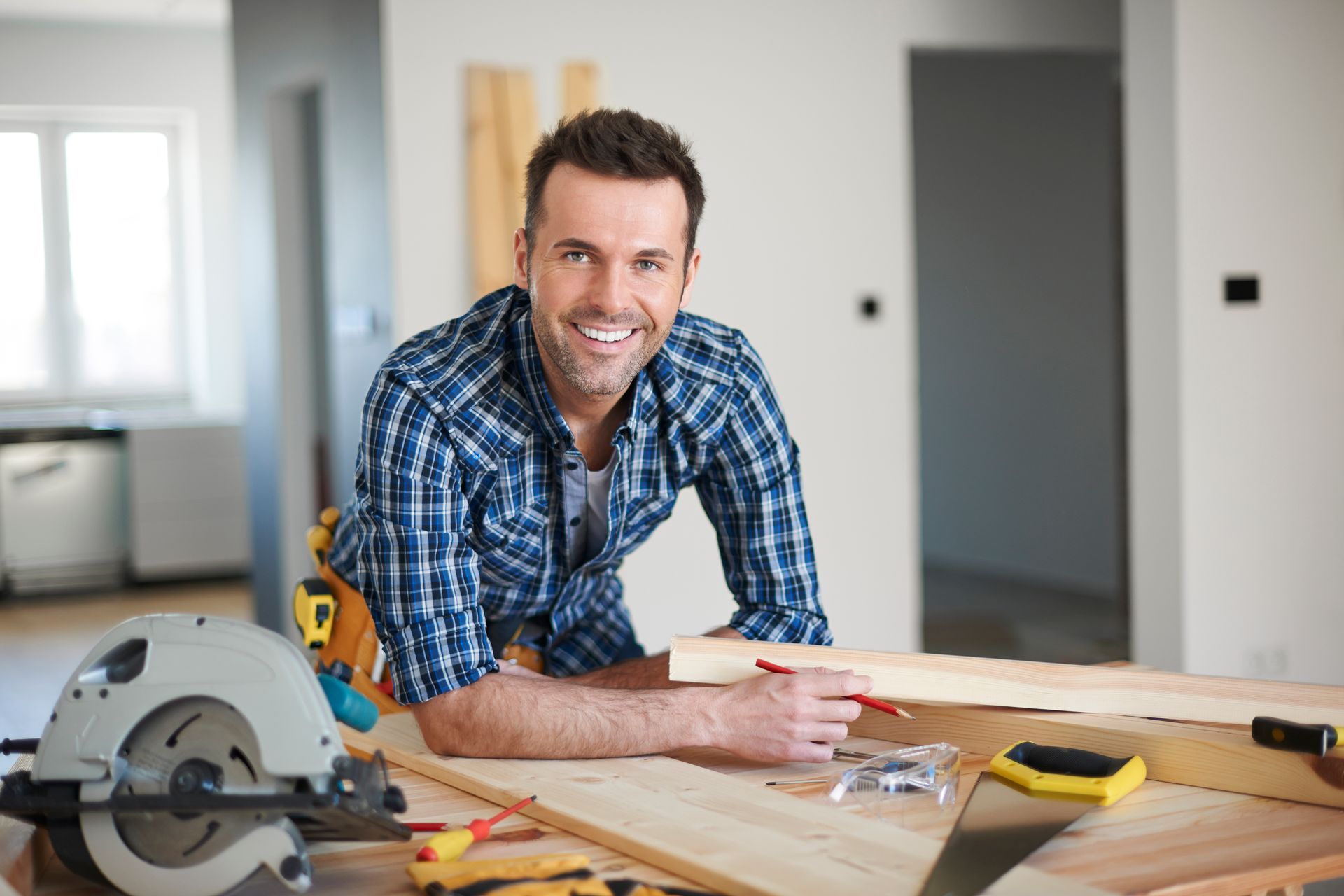 A man is sitting at a table holding a piece of wood.