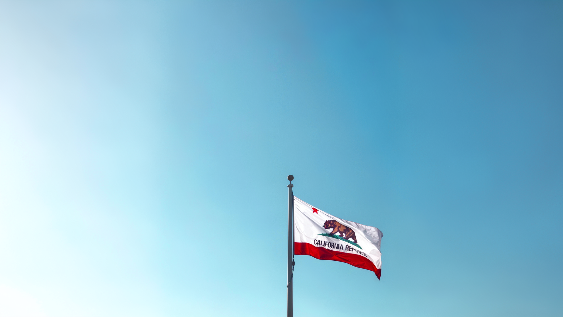 California state flag waving against a clear blue sky