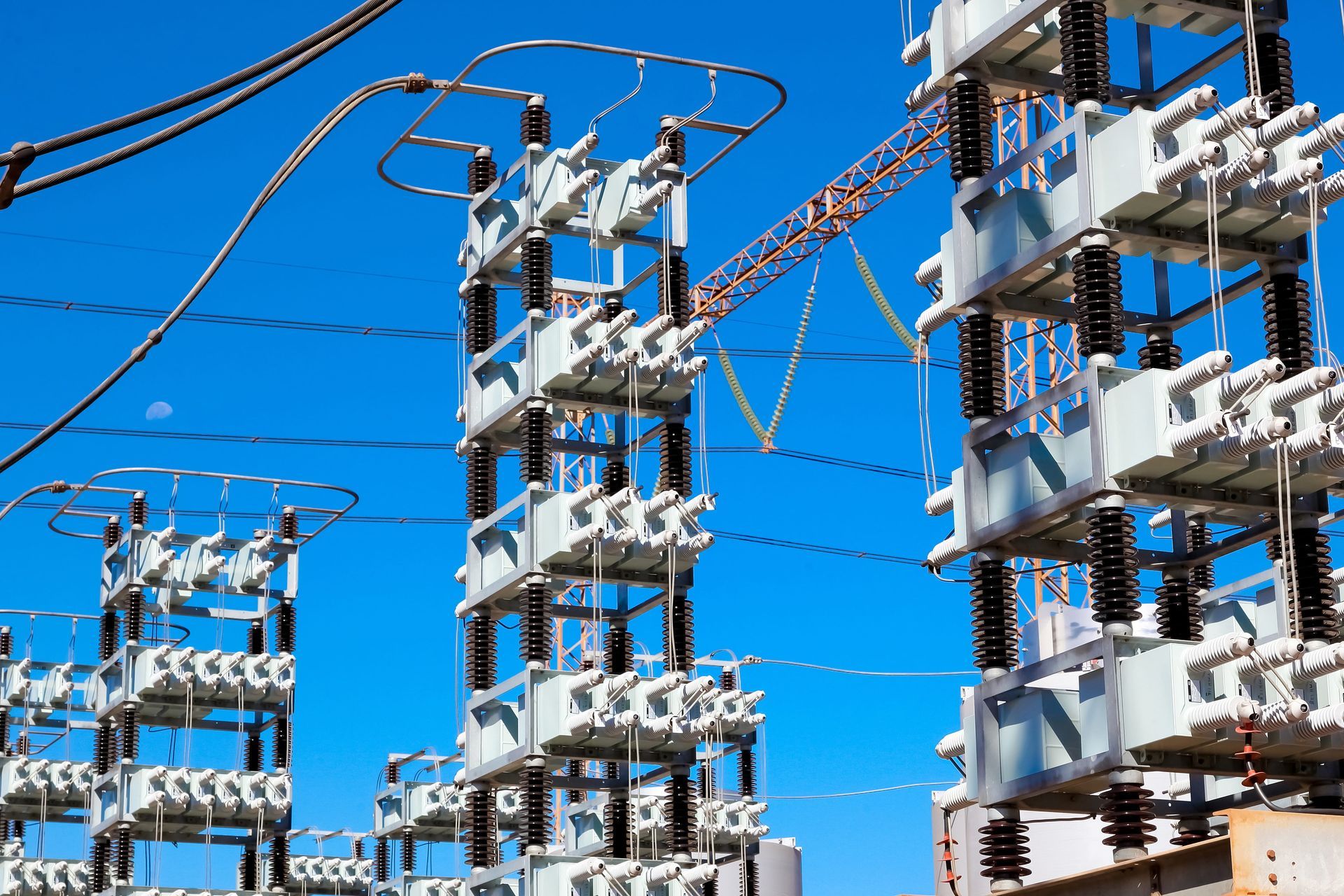 Electrical substation equipment and power lines against a clear blue sky