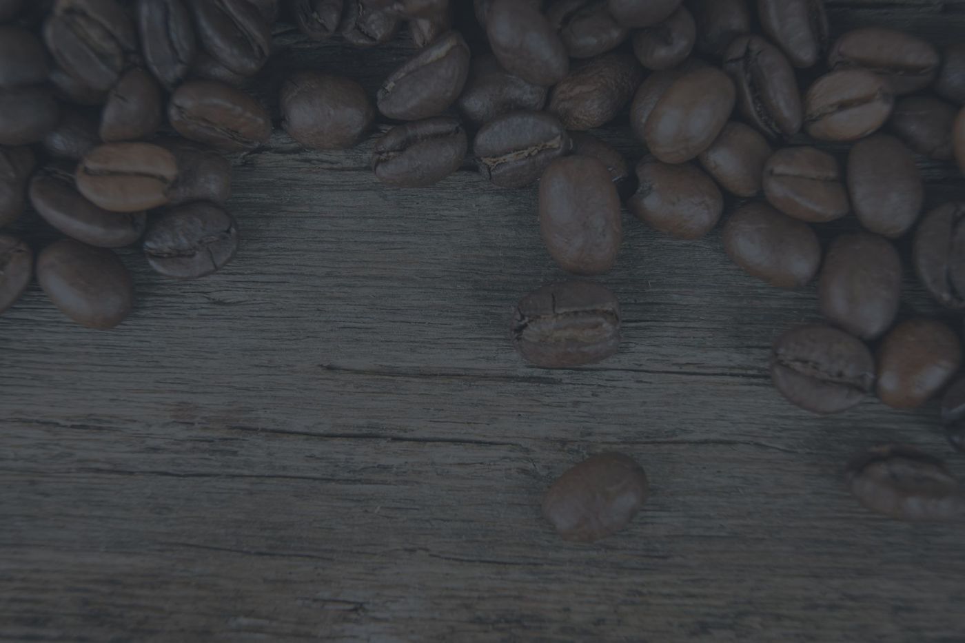 A pile of coffee beans on a wooden table.