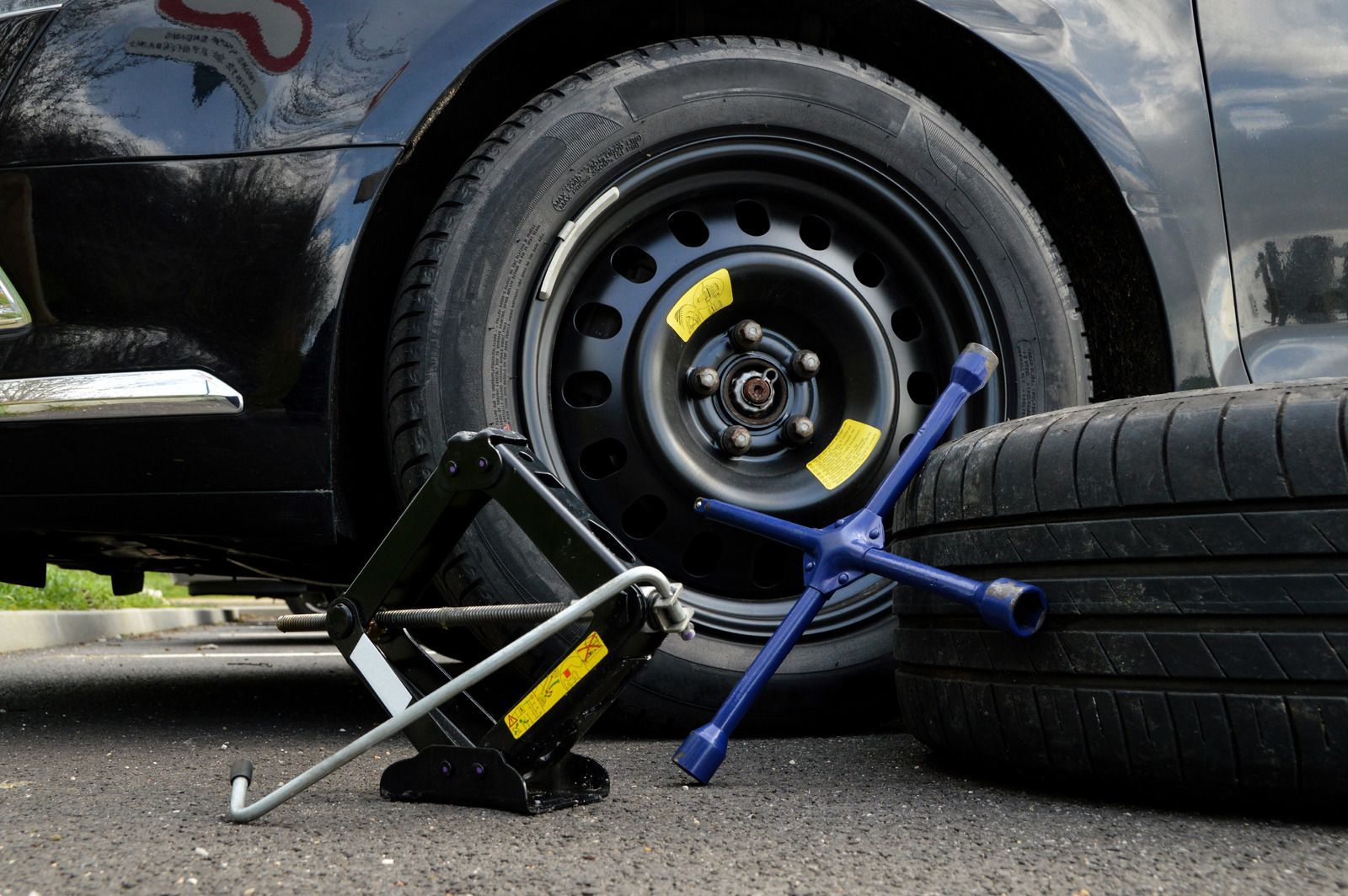 A car with a flat tire and a jack.