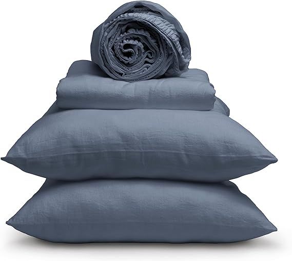 Stack of folded blue-gray bedding with a rolled blanket on top