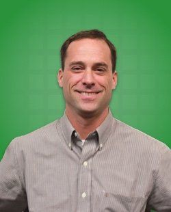 Ryan Basile in a grey striped shirt, smiling.