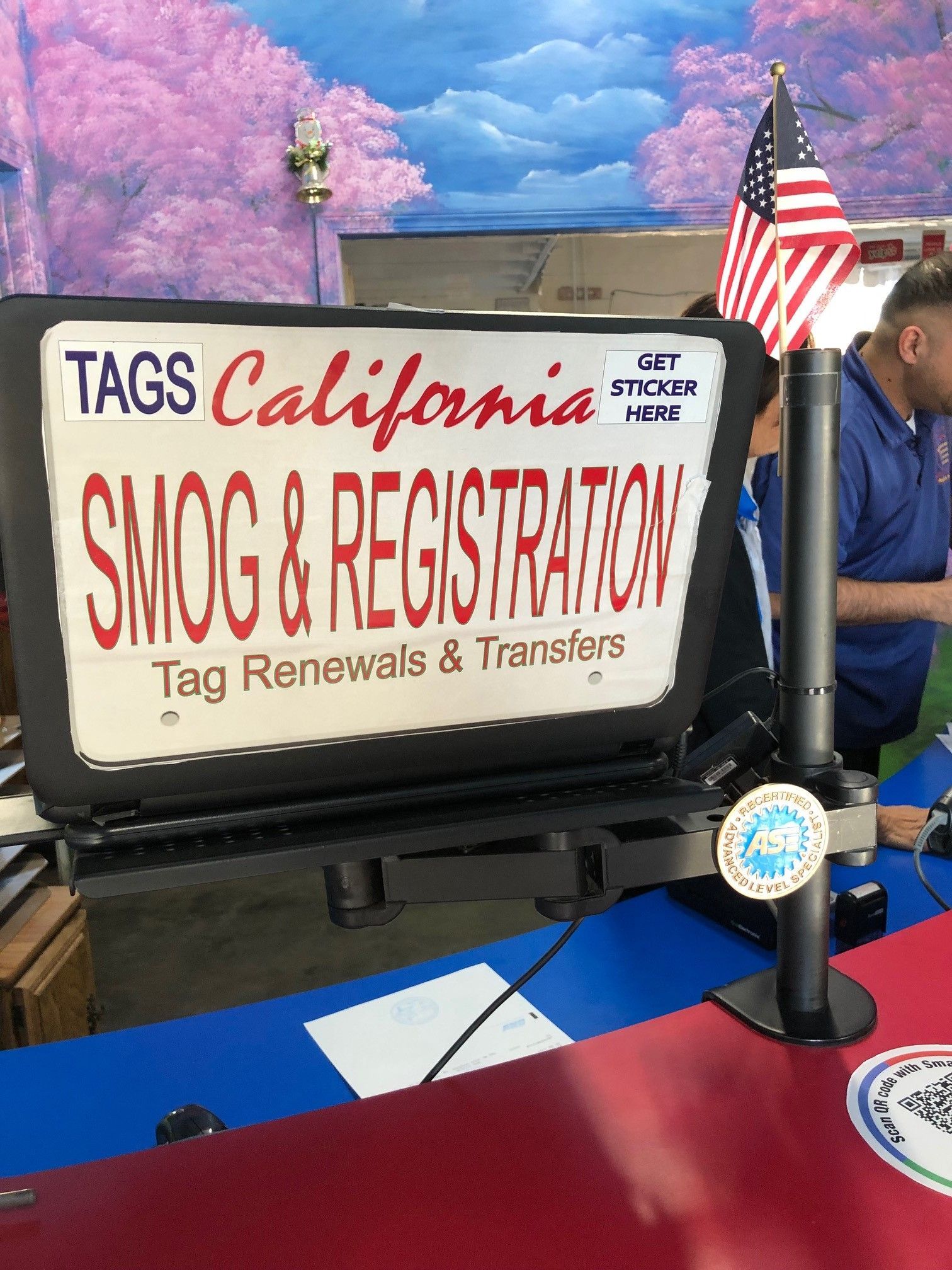 TAGS California Smog & Registration sign with American flag on a counter
