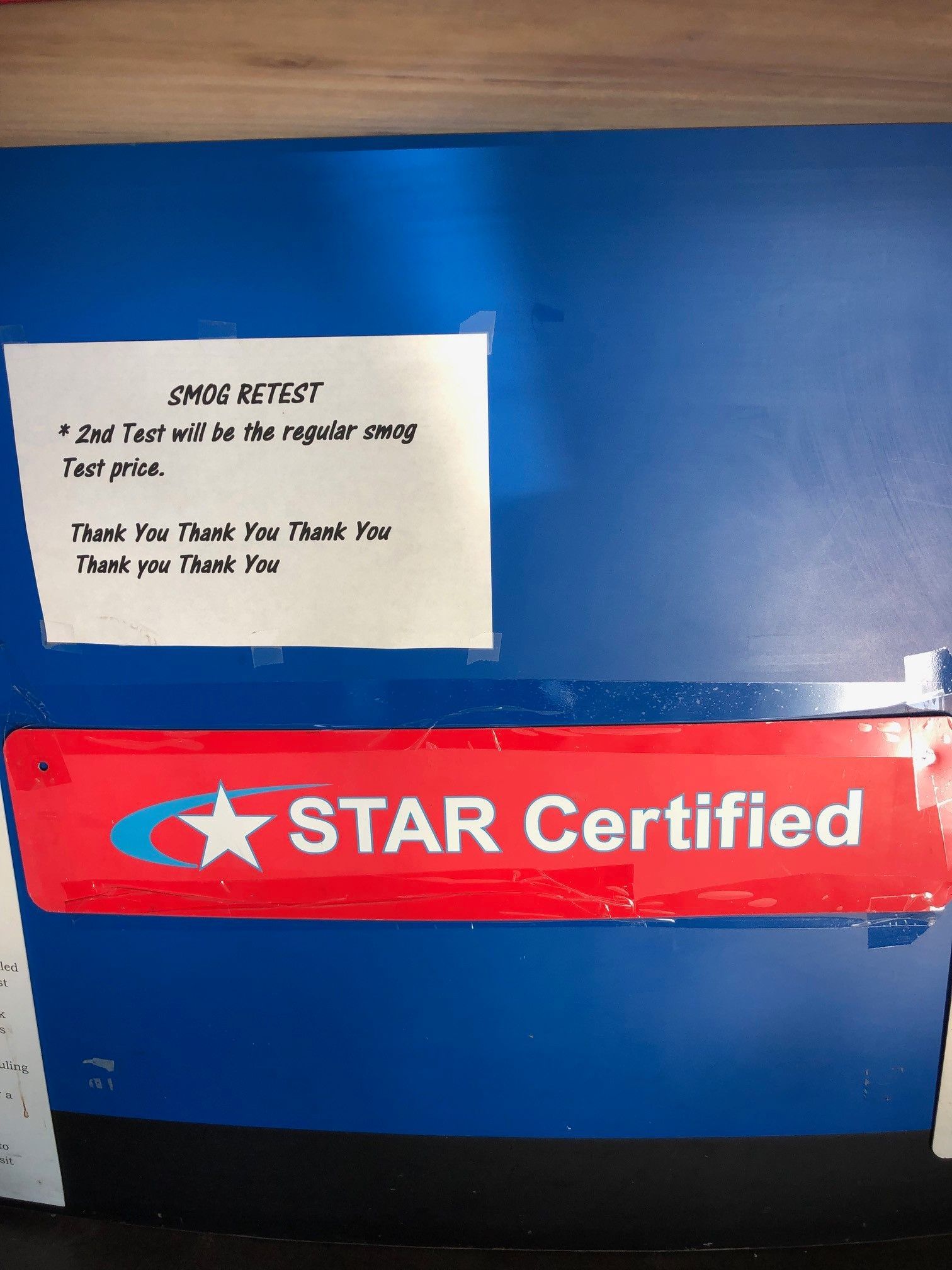 Blue wall with red “STAR Certified” sign and a small white note above it.