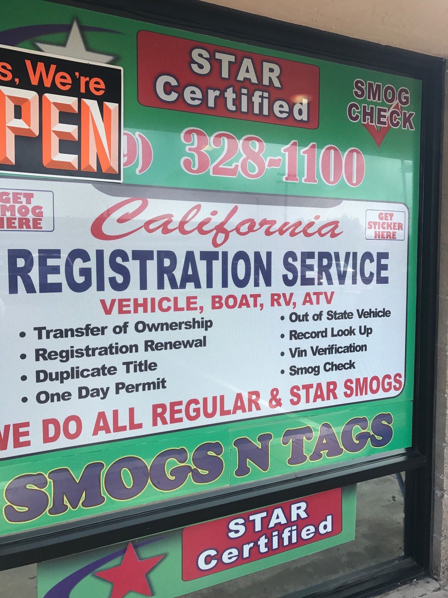 Colorful auto registration and smog service sign reading “SMOGS N TAGS” and “California Registration Service”