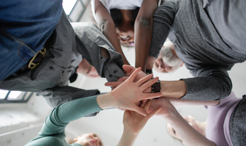 group of people putting hands together