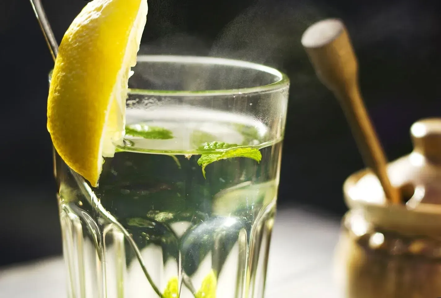 A glass of water with a slice of lemon in it