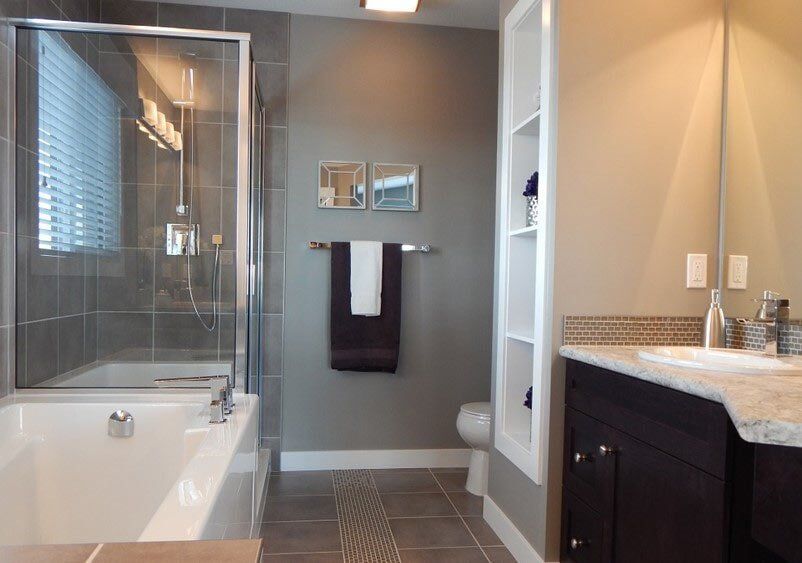 A bathroom with a tub, sink, toilet and shower