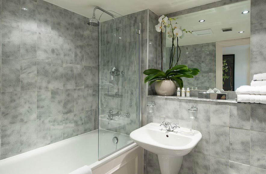A bathroom with a sink, bathtub, shower and mirror