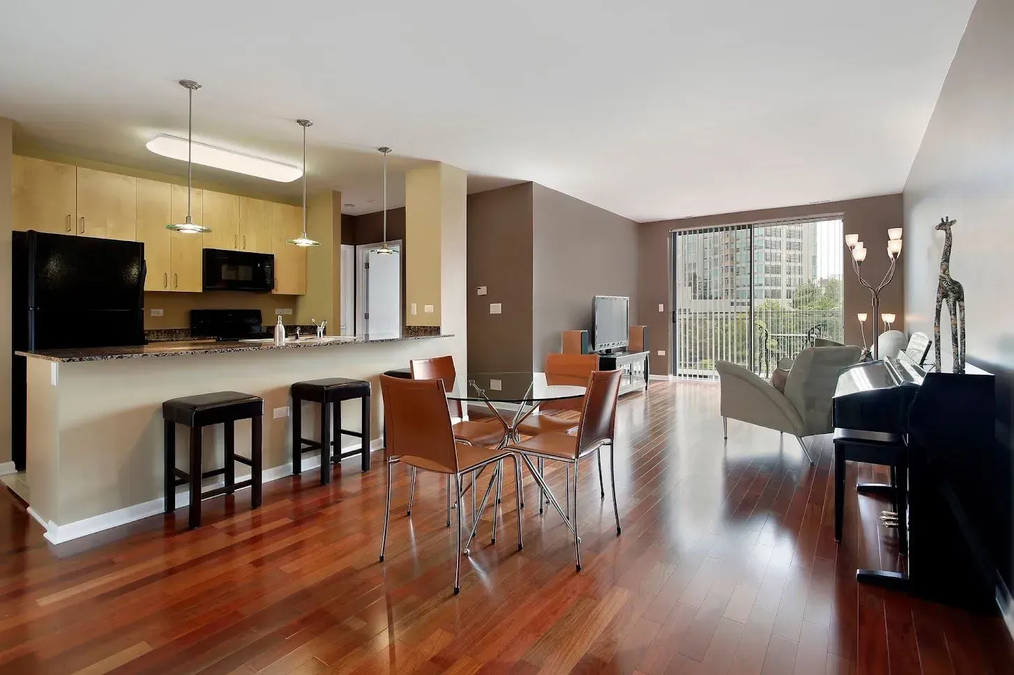 A living room with hardwood floors and a piano