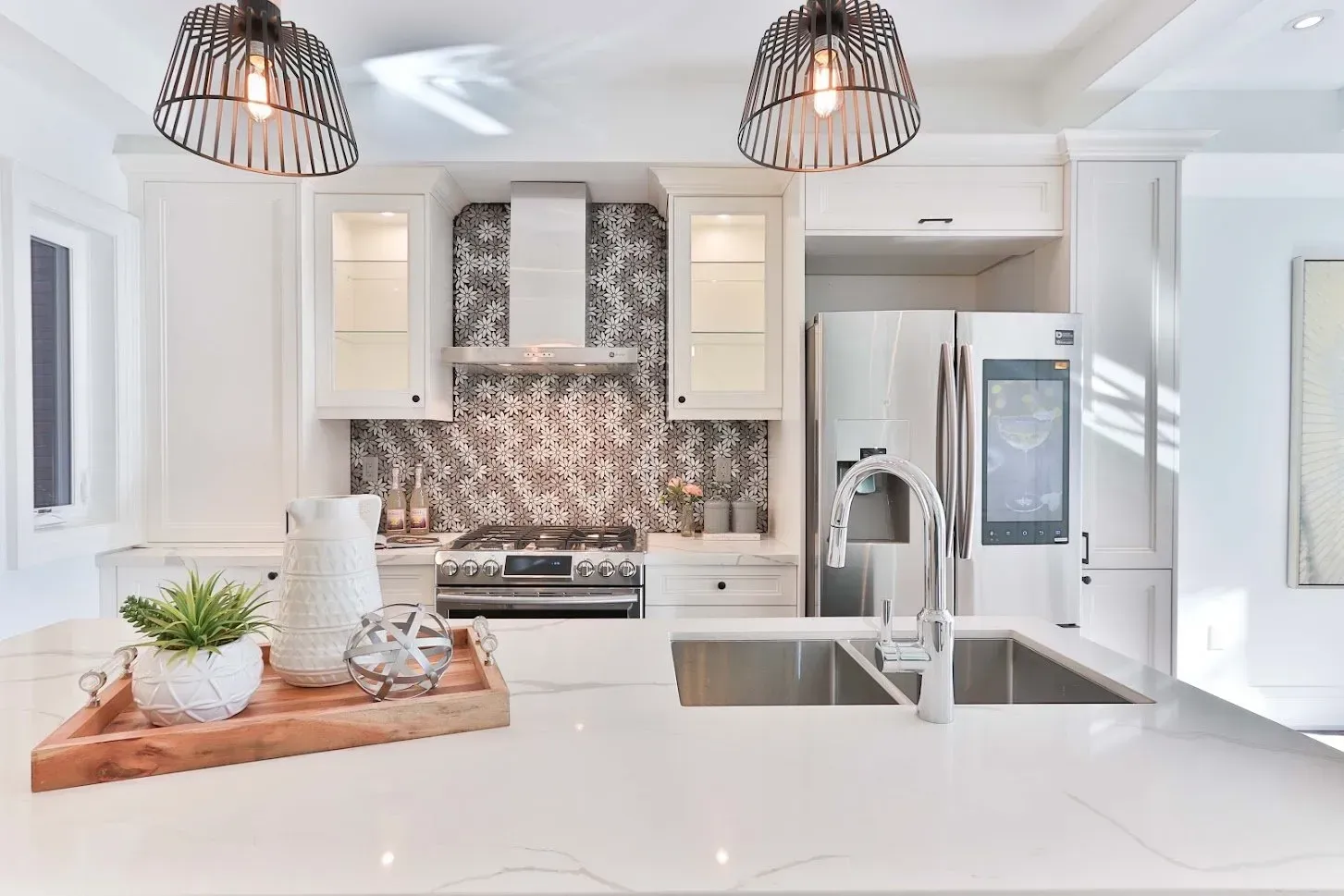A kitchen with white cabinets , a sink , a refrigerator and a stove.