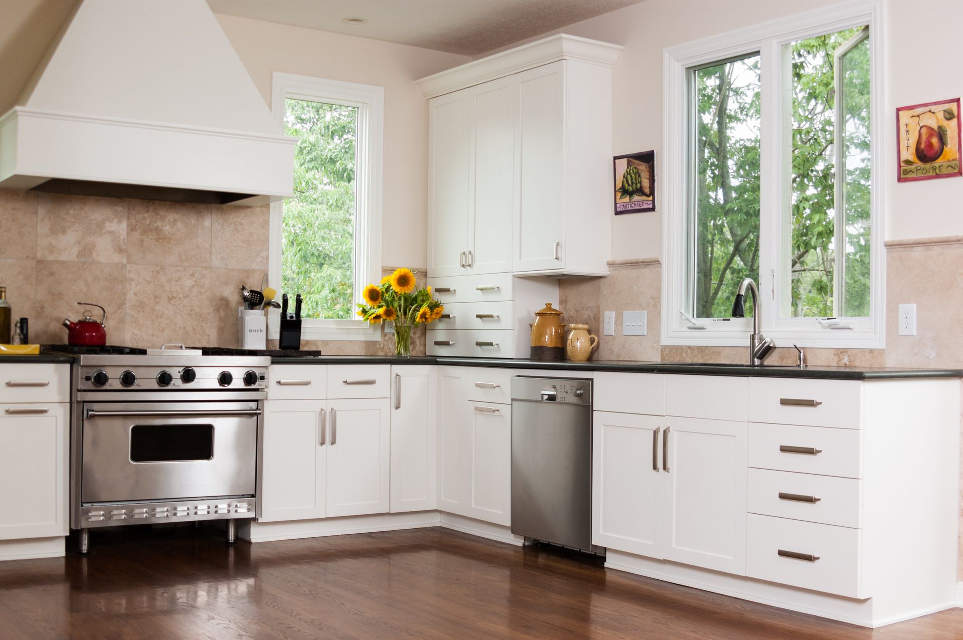 A kitchen with white cabinets and stainless steel appliances