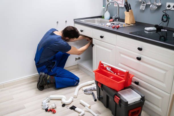 Plumber from Oak Creek Plumbing and Remodeling repairing a kitchen sink in Milwaukee, WI.