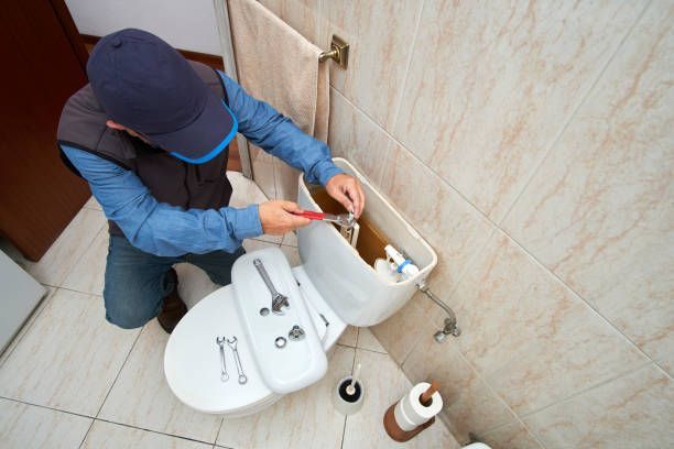 Professional plumber repairing a toilet cistern | Oak Creek Plumbing |Milwaukee, WI 