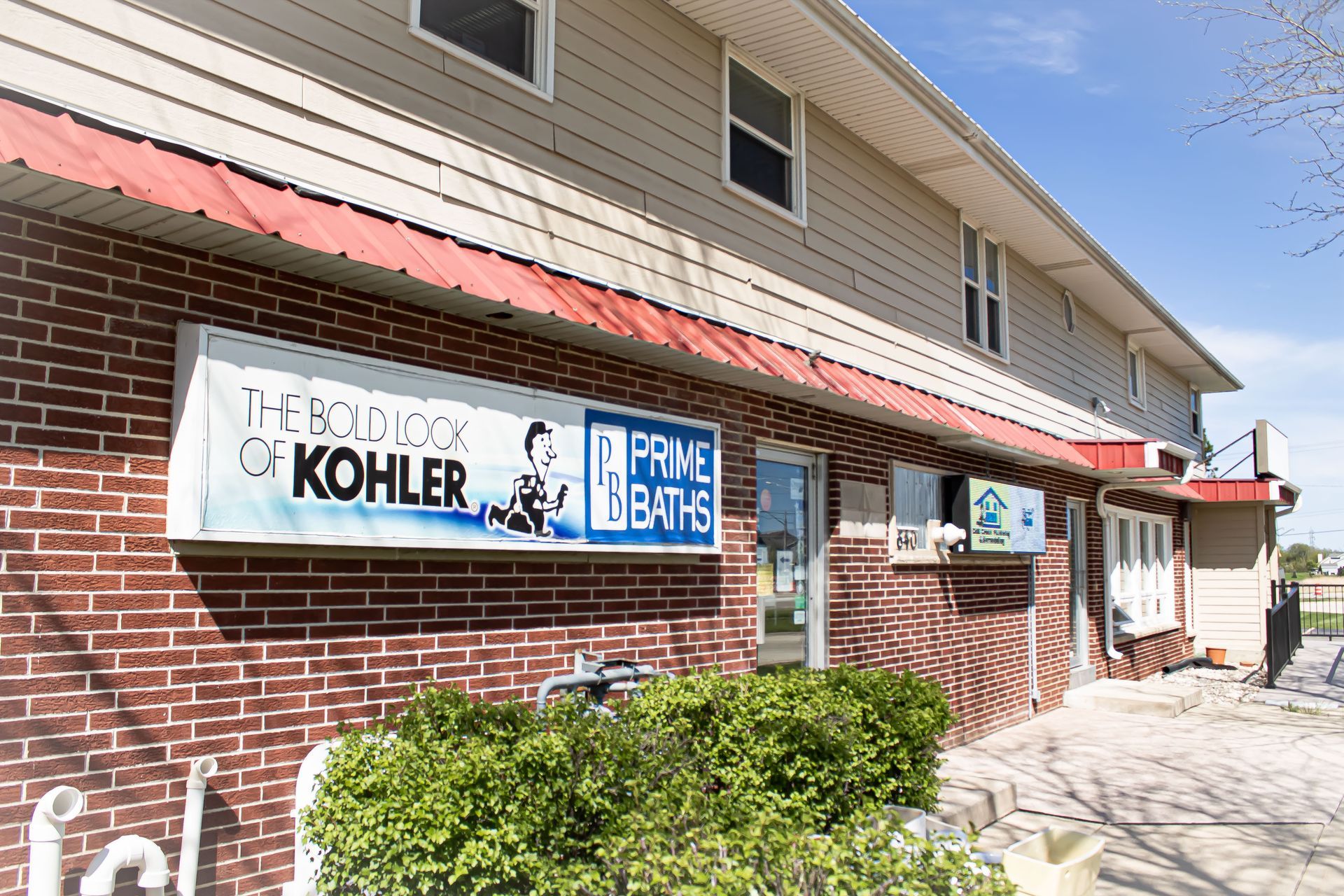 Brick storefront with awnings and signs for plumbing and Kohler products