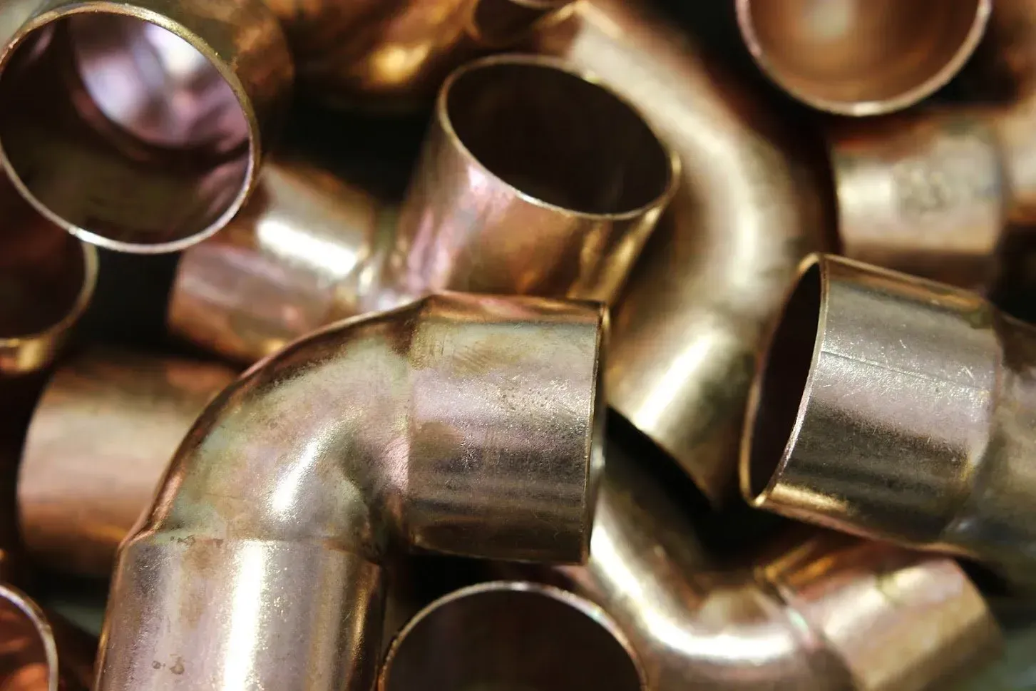 A pile of copper pipes sitting on top of each other on a table.