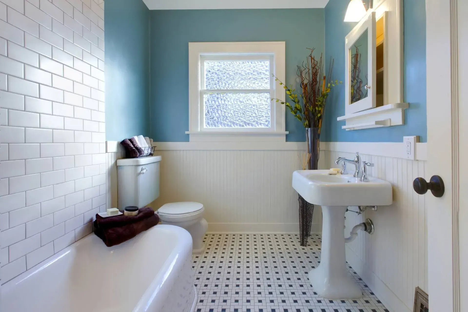 A bathroom with blue walls and white tiles