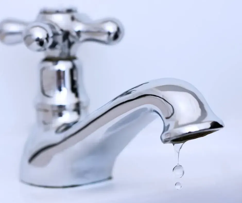 A close up of a faucet with water dripping from it