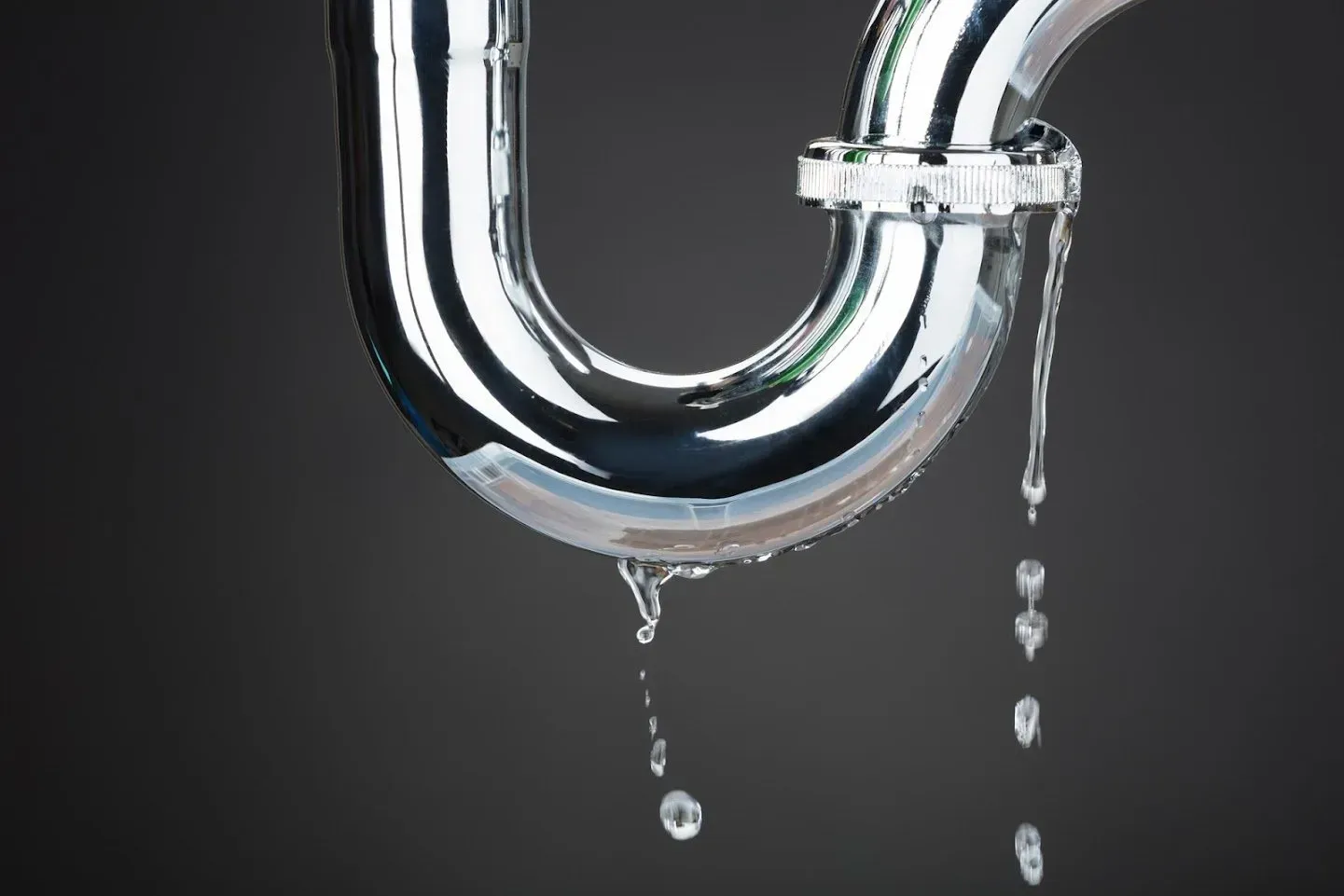 A close up of a drain pipe with water leaking out of it.