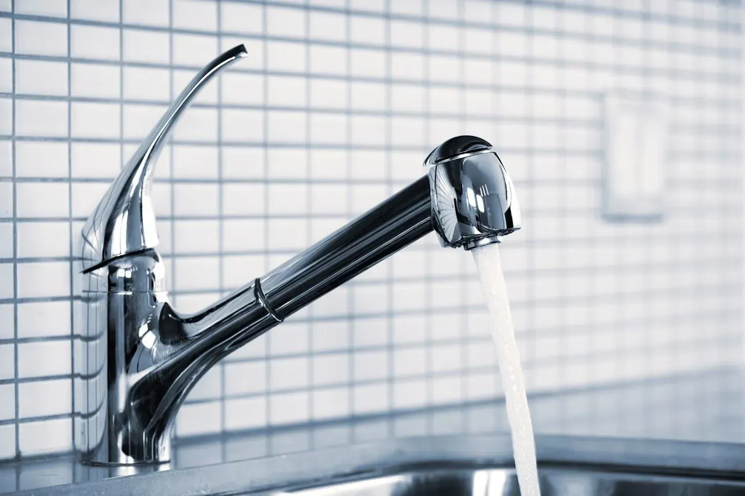 A kitchen sink with water running from a faucet.