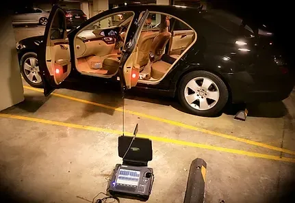 A black car is parked in a parking garage with its doors open.