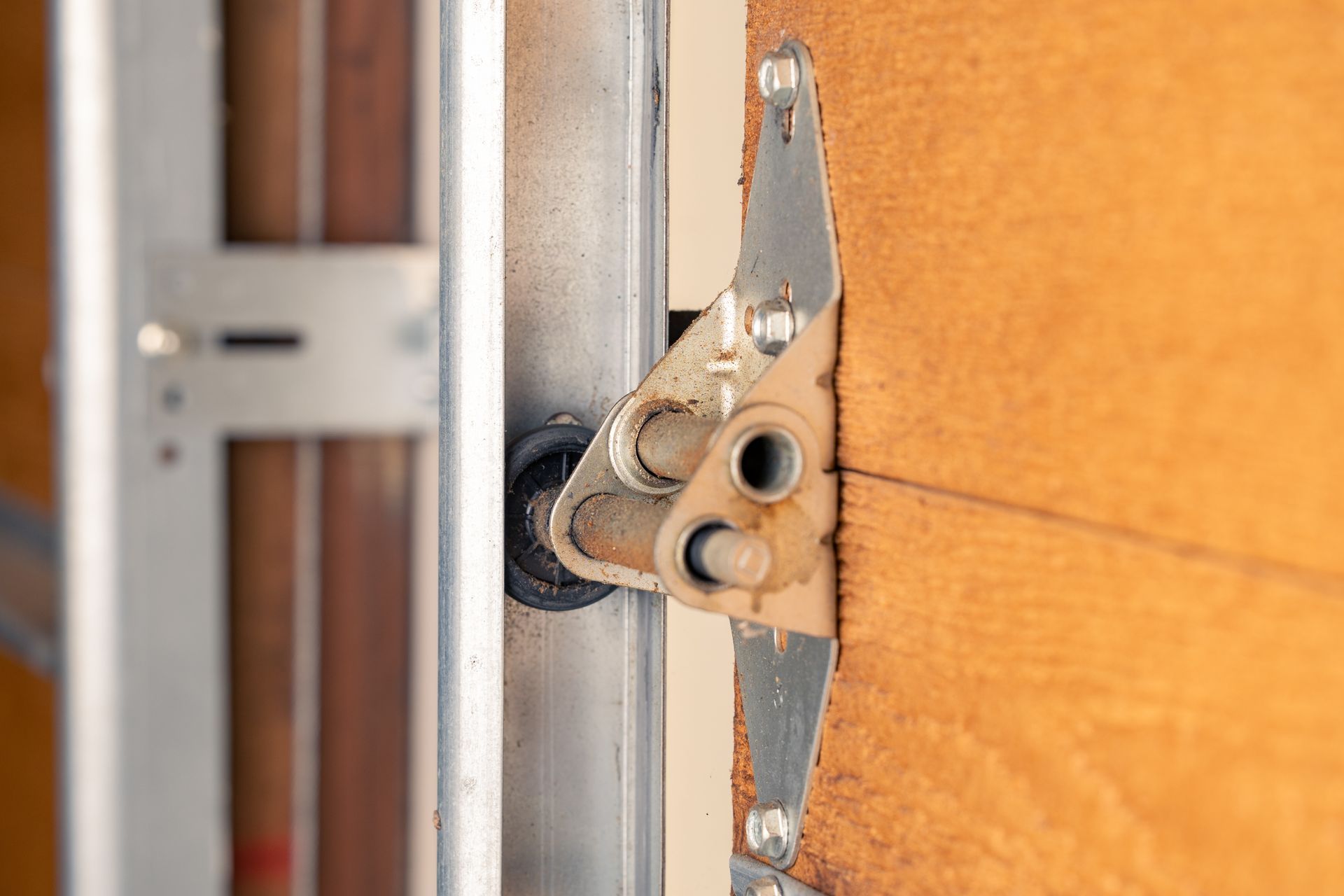 Close-up of garage door roller and hinge bracket on track. Close-up of garage door roller and hinge bracket on track.