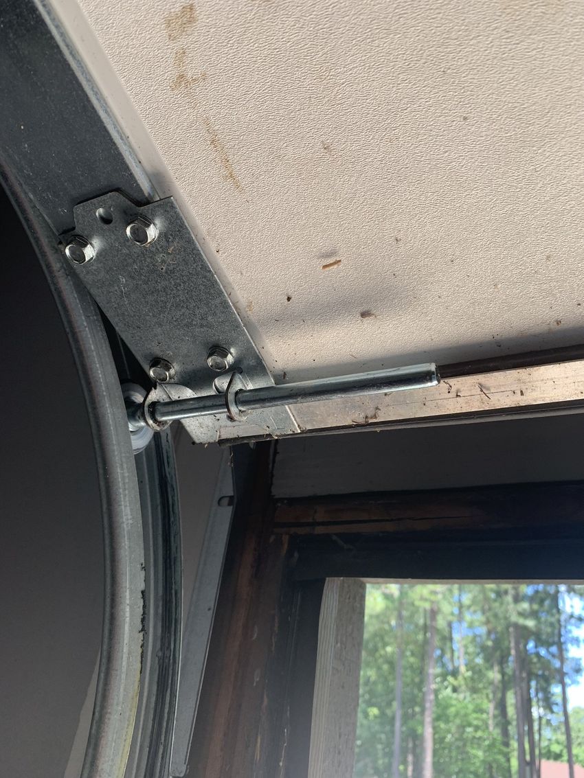 Close-up of a window frame corner with damaged trim and exposed fasteners indoors