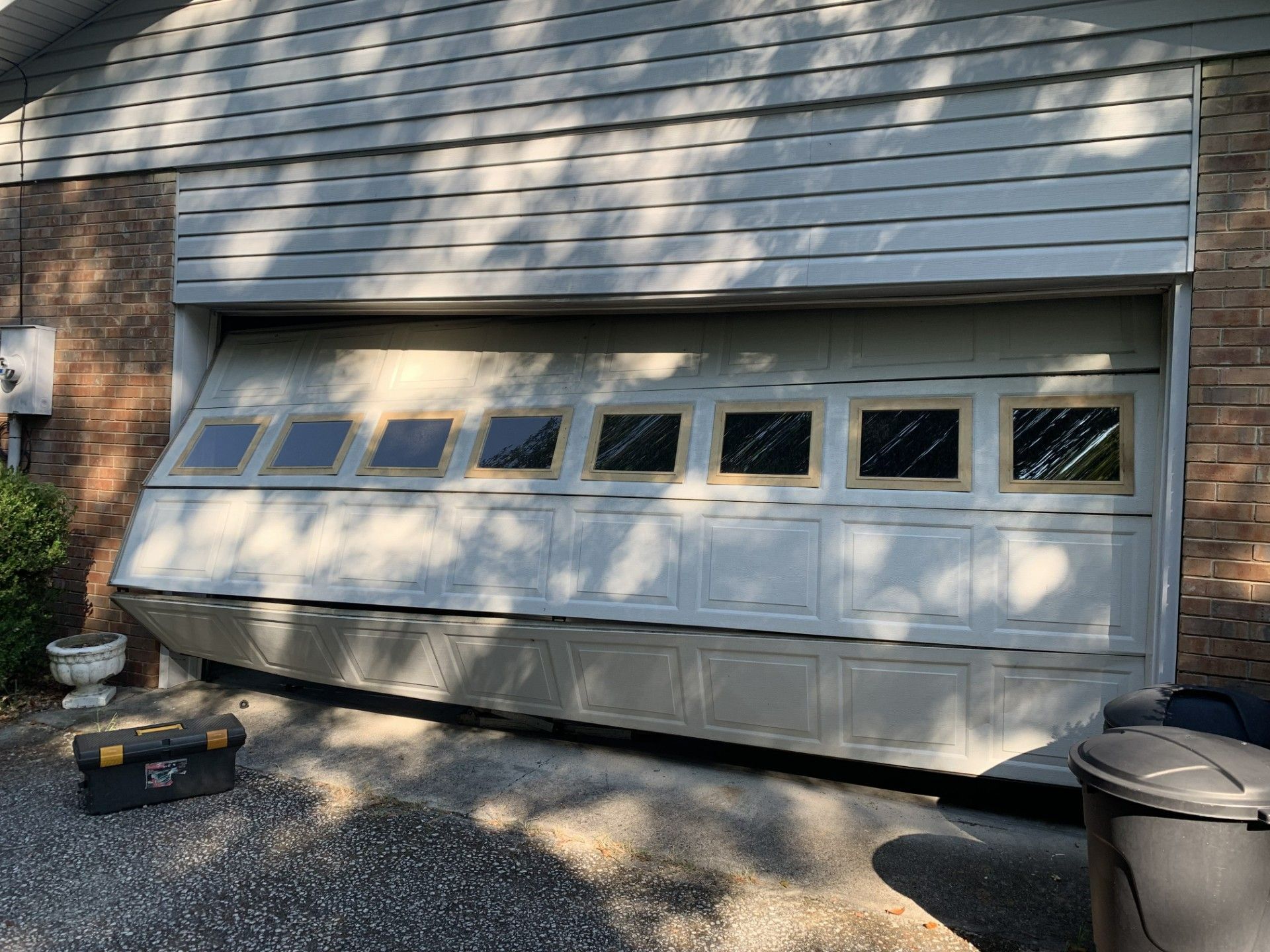 Closed white garage door with small windows on a brick house exterior