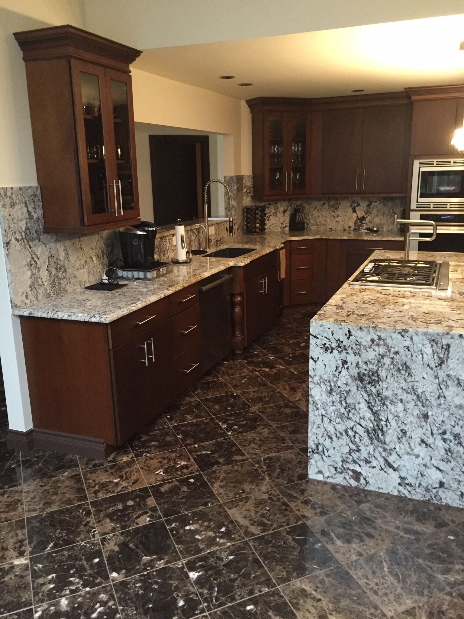 A kitchen with granite counter tops and wooden cabinets.