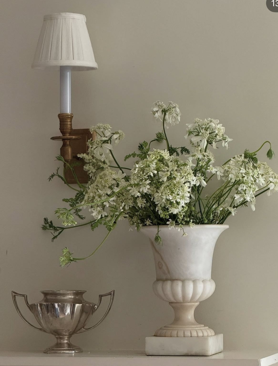 close up image of rustic lamp and flower vase with white flowers