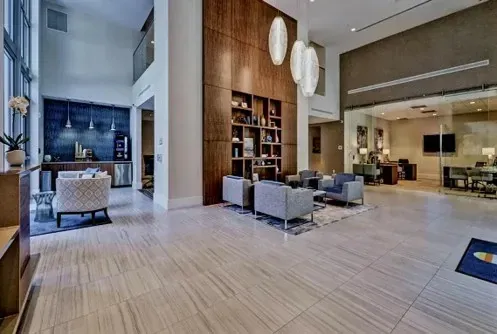 Spacious lobby with wood paneling, seating areas, and modern lighting.