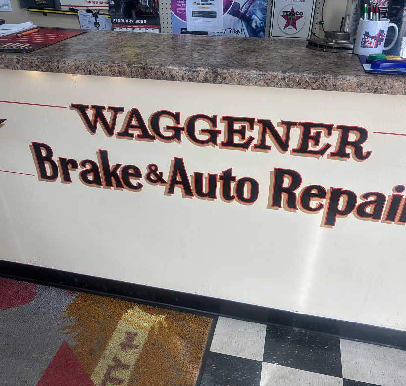 Reception counter at Waggener Brake & Auto Repair with a checkerboard floor and a logo mug. | Waggener Brake and Auto Repair