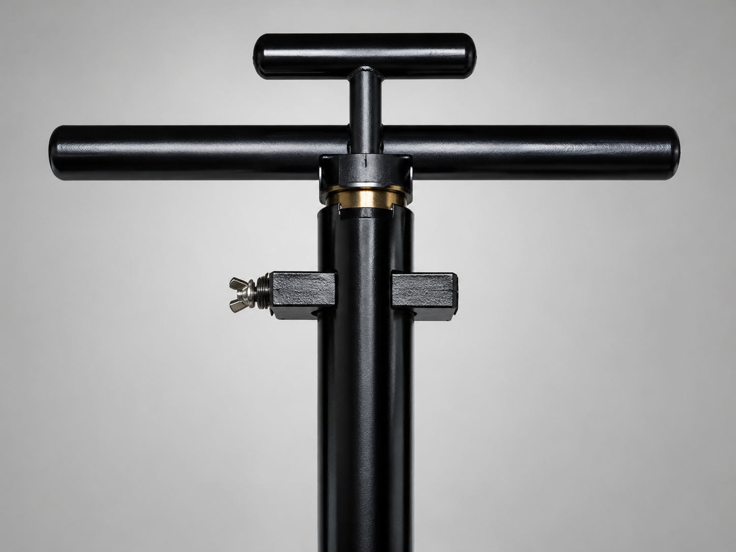 Black T-handle bicycle pump against a light background