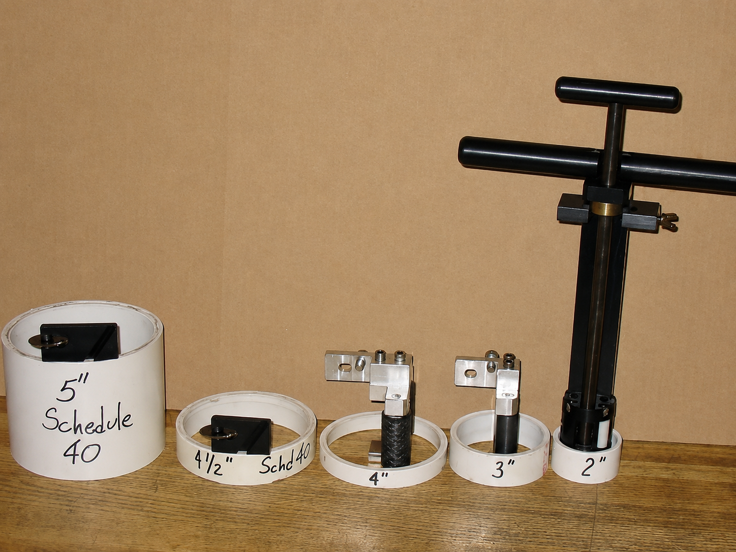 Coffee tamper set with scale, dispenser rings, and black tamper on a tan background
