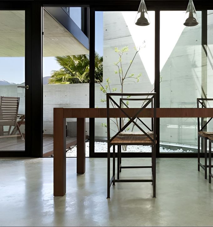 A Dining Room With A Table And Chairs And A Large Glass Window — GGS Alice Glass & Aluminium In Ciccone, NT