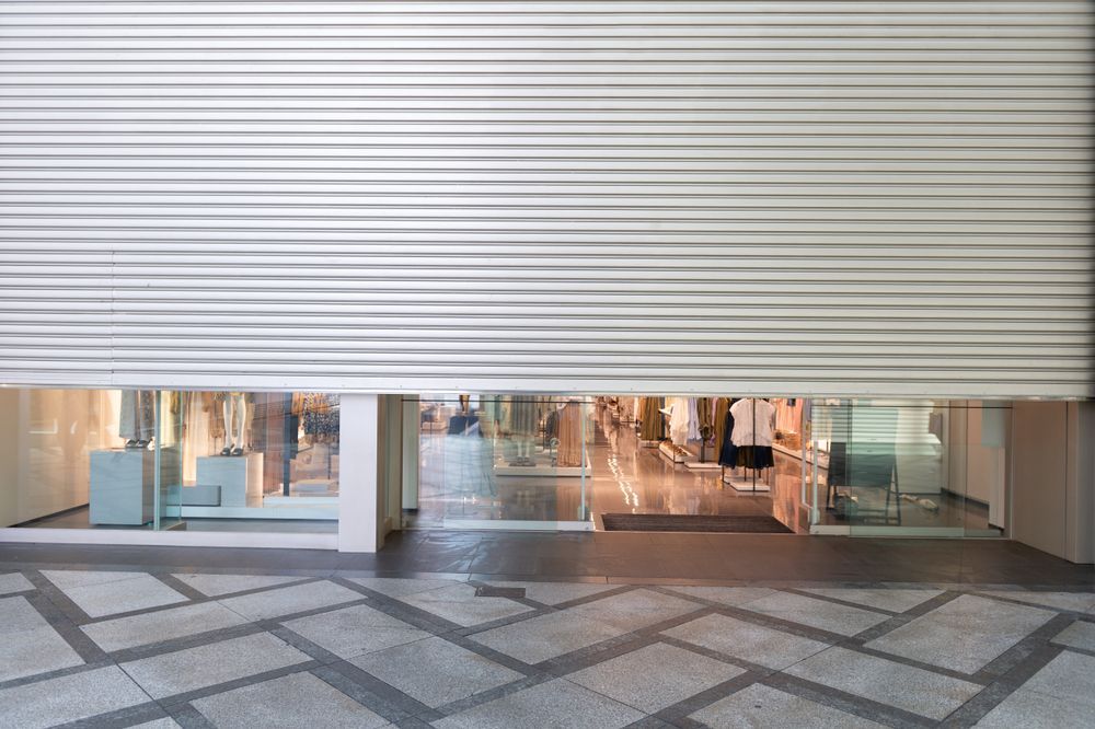 Store Front With a Partially Closed Metal Shutter