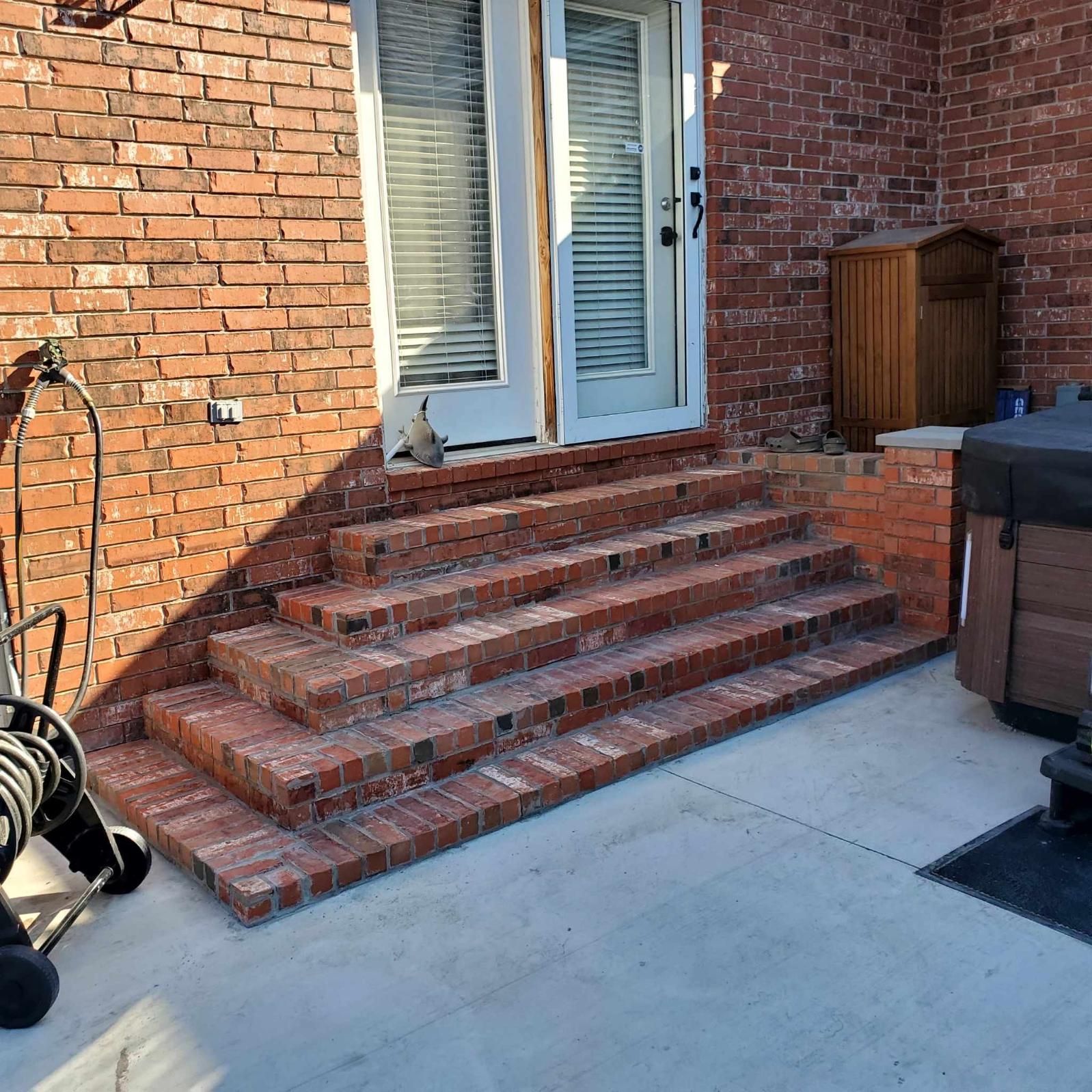 A brick house with stairs leading up to the front door.