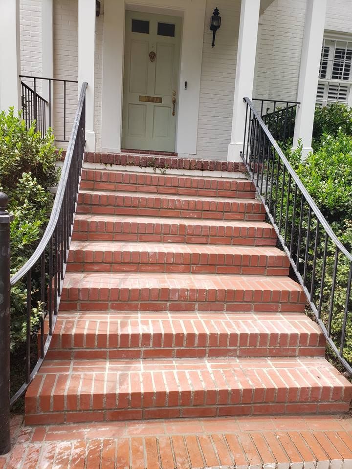 A set of brick stairs leading up to a white house.