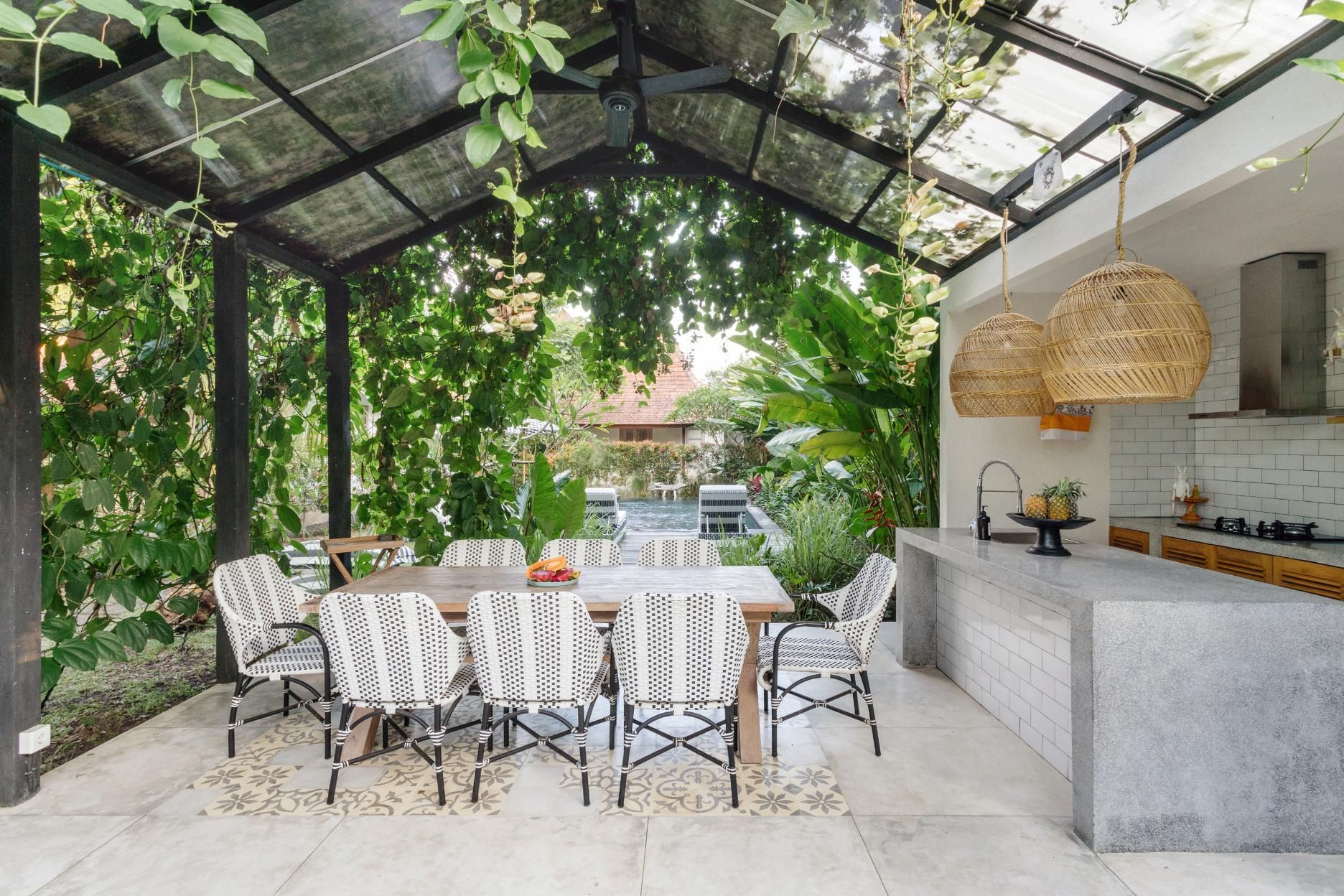 A dining room with a table and chairs under a glass roof.