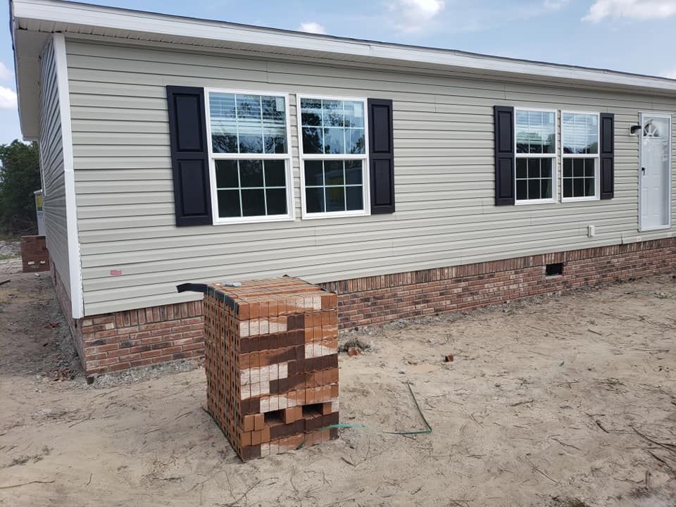 A mobile home with a stack of bricks in front of it.