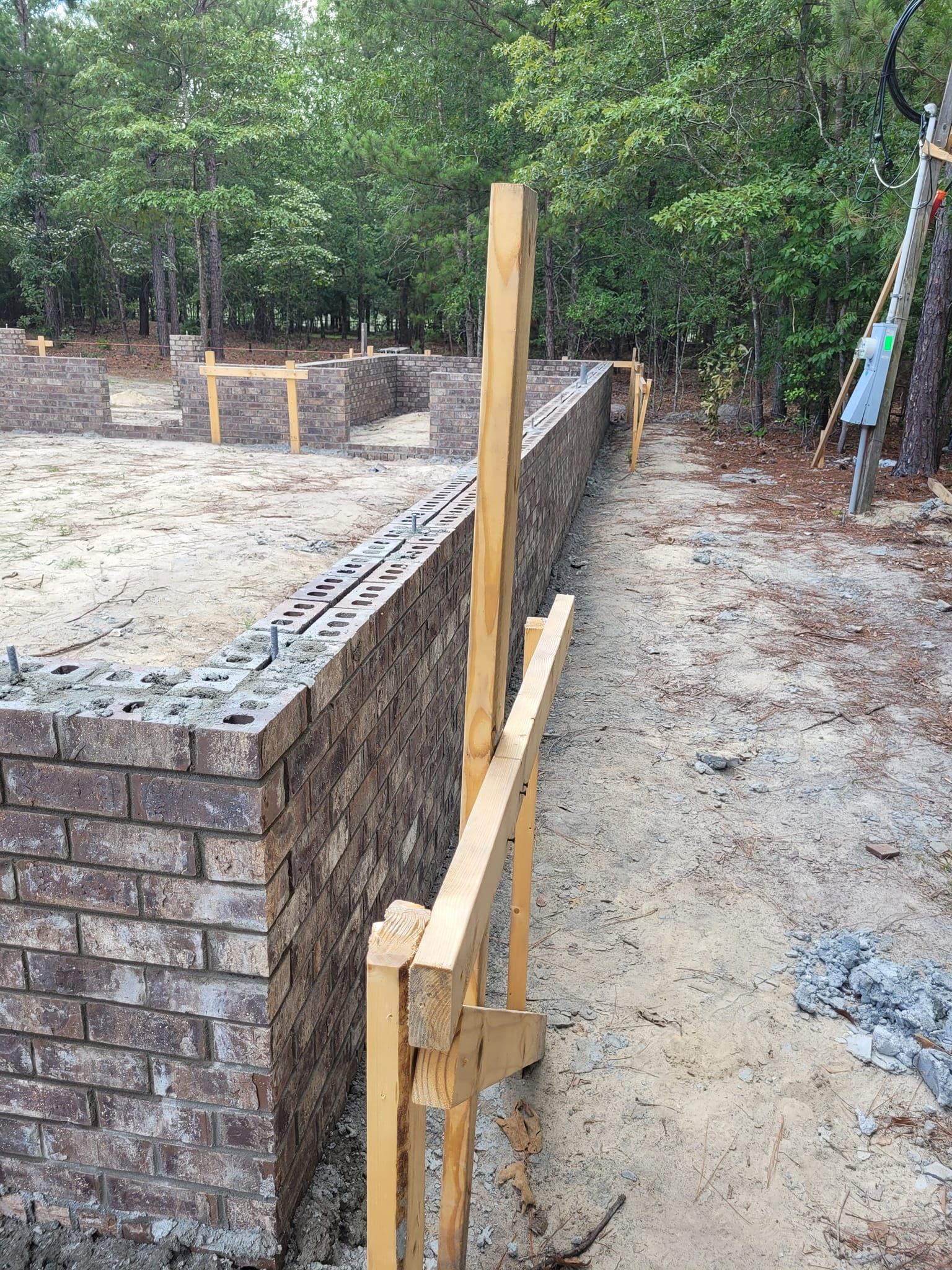 A Brick Wall is Being Built in the Middle of a Dirt Field.
